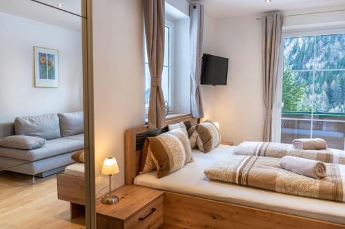 a bedroom with a bed and a couch and a window at Pension Waldhauser in Rennweg