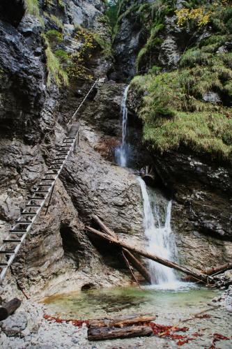 a waterfall on the side of a rocky mountain with a staircase at ČÁKYHO KÚRIA - mezonetový apartmán s krbom a saunami in Smižany