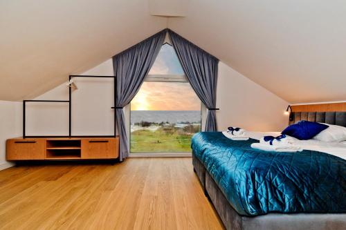 1 dormitorio con cama y ventana grande en BlueApart Apartamenty Na Plaży Jastarnia en Jastarnia