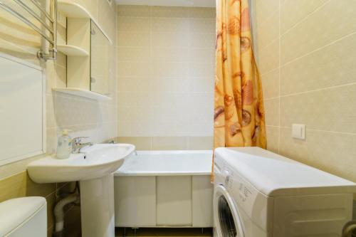 a bathroom with a sink and a washing machine at Apartments on Ploscha Yakuba Kolasa in Minsk