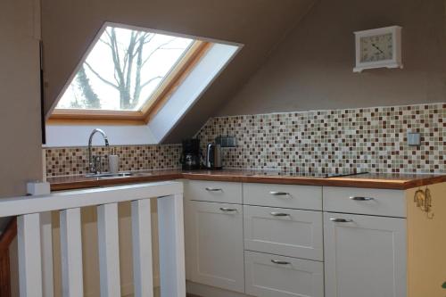 a kitchen with a sink and a window at Gastenverblijf Peppelmate in Doetinchem