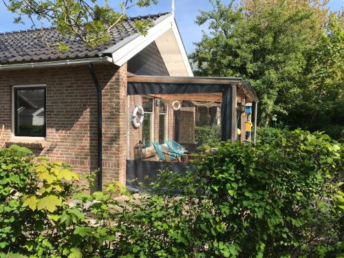 Κήπος έξω από το BelleMare Bungalow Lauwersmeer mit überdachte Veranda und eingezäuntem Garten