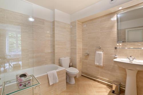 a bathroom with a tub and a toilet and a sink at Chateau de la Rozelle in Cellettes