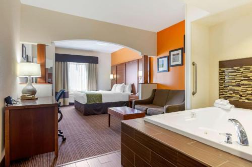 a hotel room with a bed and a bathroom at Comfort Suites Stevensville - St Joseph in Stevensville