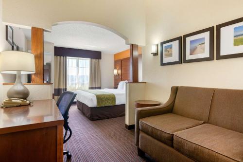 a hotel room with a bed and a couch at Comfort Suites Stevensville - St Joseph in Stevensville
