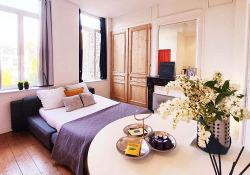 - une chambre avec un lit et une table fleurie dans l'établissement Lille Centre Ville, Beaux Arts et Grand Palais, Bienvenue chez Nestyou Lille, à Lille