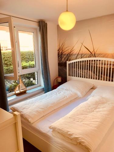 a bedroom with two beds and two windows at Strandperle in Timmendorfer Strand