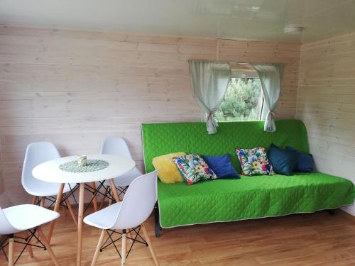 a green couch in a room with a table and chairs at Miodowy Zakątek Całoroczne Domki i Pokoje przy Suntago, Deepspot, Pyszne Śniadania, Grill in Mszczonów