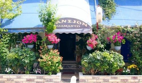 a building with flowers and plants in front of it at Diamanto Rooms in Eretria