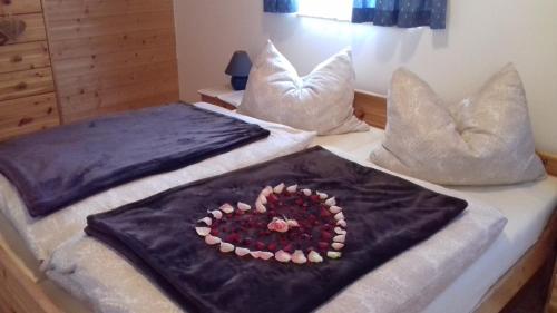 two beds with pillows with a heart on them at Chalet zur Schmiede in Liebenfels
