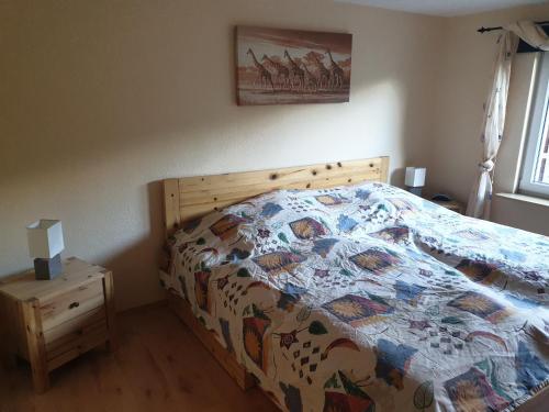 ein Schlafzimmer mit einem Bett mit einer Decke darauf in der Unterkunft FERIENWOHNUNG AM SEE in Seehof