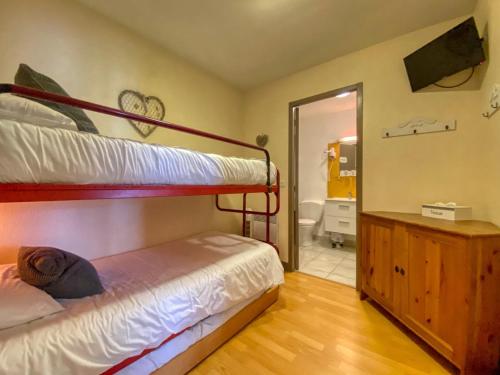 a bedroom with a bunk bed and a mirror at Hôtel Le P'tit Monde in Montignac