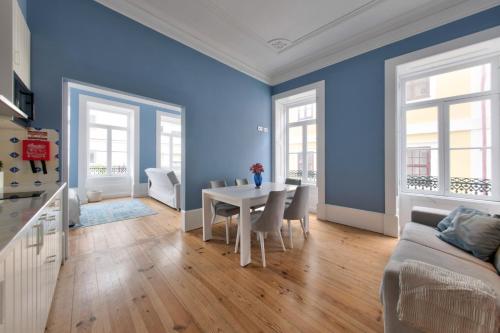 a dining room with blue walls and a table and chairs at Aveiro History Apartments in Aveiro