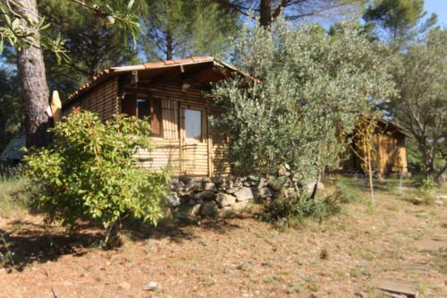 a log cabin with a stone wall in front of it at Mas Les Micocouliers in Saint-Christol-lès-Alès