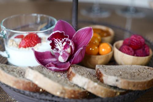 um prato de pão com uma flor e fruta sobre ele em Maison Silvia em Villorba