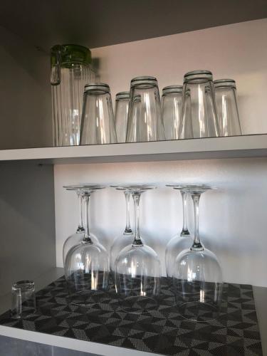 a row of wine glasses sitting on shelves at Good Night apartaments in Panevėžys