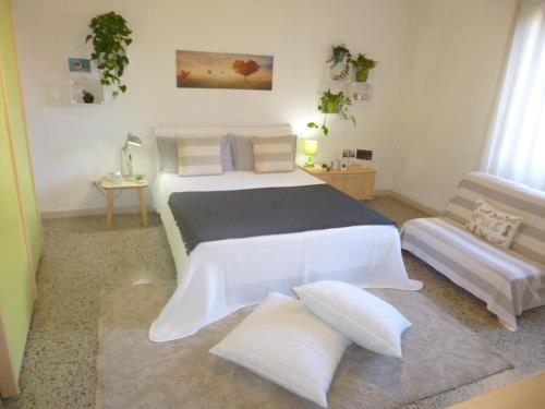 a bedroom with a large white bed and a couch at EcoBoutique house, self check-in - free car parking in Cagliari
