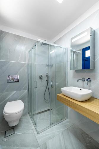 a bathroom with a shower and a toilet and a sink at Creta Sky in Achlia