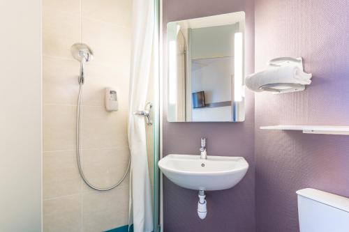 a bathroom with a sink and a shower at B&B HOTEL Tours Nord 2 La petite Arche in Tours
