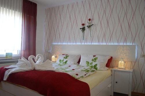 um quarto com uma cama com um cobertor vermelho e branco em Zum Sauerländer Altstadt em Medebach