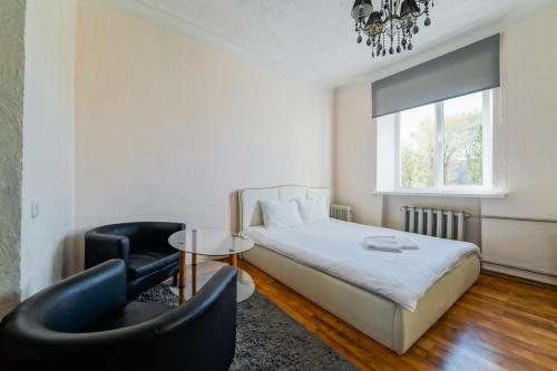 1 dormitorio con 1 cama, mesa y sillas en In the center of Minsk en Minsk