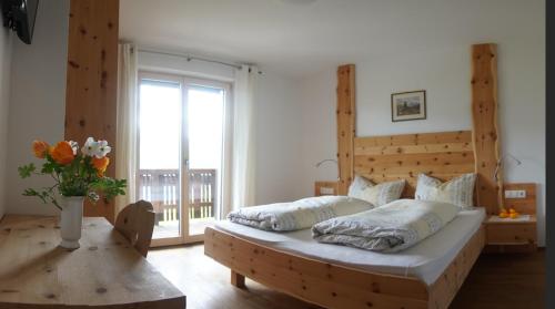 a bedroom with a large bed and a large window at Agriturismo Gfaderhof in Bressanone