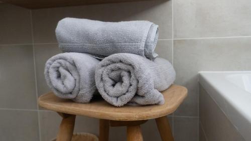 une pile de serviettes assises sur un tabouret dans la salle de bains dans l'établissement Agriturismo Gfaderhof, à Bressanone