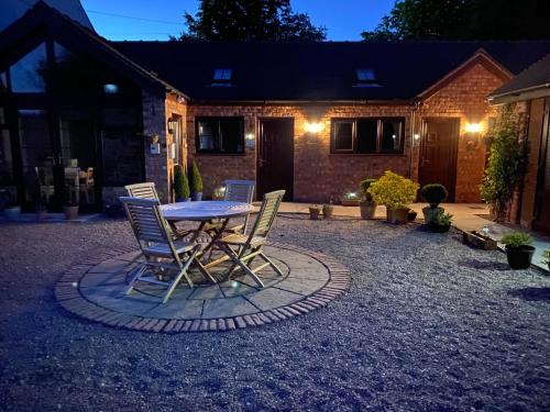 eine Terrasse mit Tisch und Stühlen vor einem Haus in der Unterkunft High View Cottage in Uttoxeter