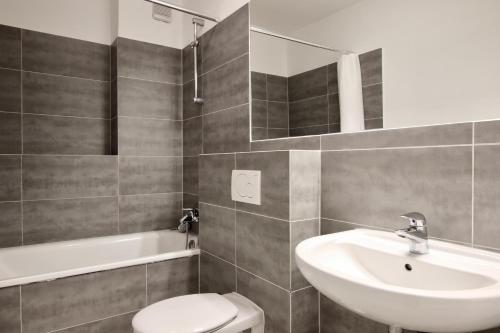 uma casa de banho com um lavatório, um WC e uma banheira em Arthouse Apartments im Pantaleonsviertel em Colônia