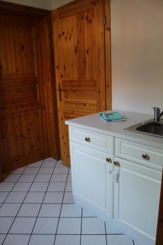 a kitchen with white cabinets and a sink at Altstadtcafé und Pension in Havelberg