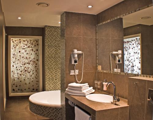 a bathroom with a tub and a sink and a mirror at Hotel Wawel in Krakow