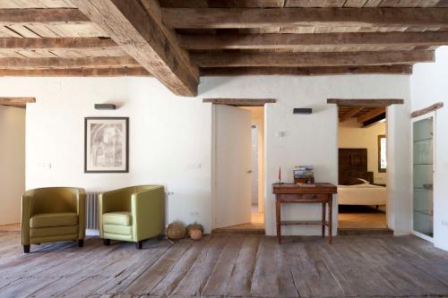 a living room with two chairs and a desk at B&B La Rectoria de Sant Miquel de Pineda in Sant Feliu de Pallerols