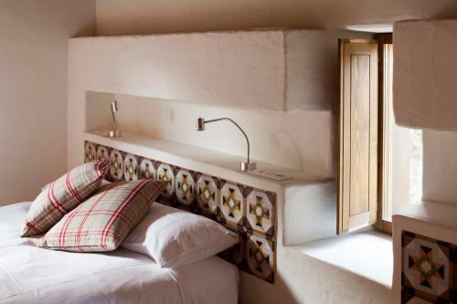 a bedroom with a bed with a headboard and a window at B&B La Rectoria de Sant Miquel de Pineda in Sant Felíu de Pallarols