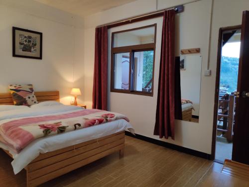 ein Schlafzimmer mit einem Bett und einem großen Spiegel in der Unterkunft 多依湾客栈Havre de paix DuoYiWan in Kreis Yuanyang