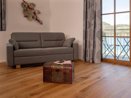 a living room with a couch and a suitcase at Brunnwirt ESSEN & WOHNEN in Fuschl am See