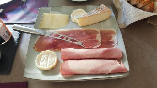 a plate with meats and cheese and a knife at Assia & Nathalie - Luxury B&B MARAIS in Paris