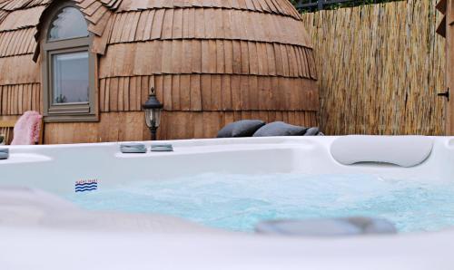 a hot tub in front of a wooden building at Igluhut Tiny House Bayerischer Wald in Zachenberg