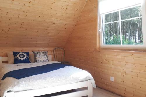 a bedroom with a bed in a log cabin at Domki letniskowe Ahoyrozewie in Rozewie