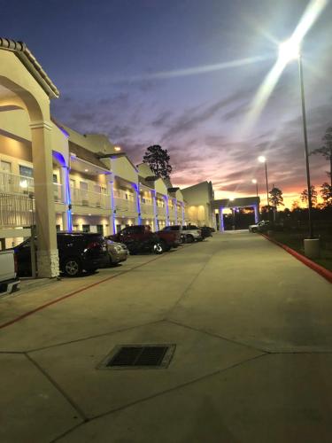 a parking lot in front of a building at night at Baymont by Wyndham Kingwood in Kingwood