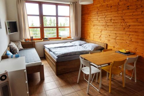 Cihlářka - horský apartmán 103 في تشيرني دول: غرفة نوم بسرير وطاولة وكراسي