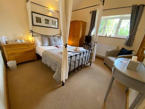 ein Schlafzimmer mit einem Bett, einer Kommode und einem Stuhl in der Unterkunft High View Cottage in Uttoxeter