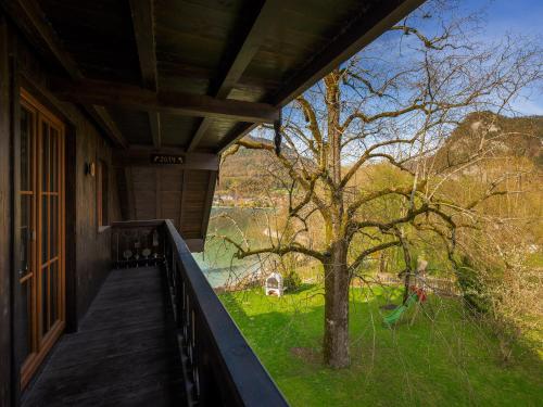 a porch of a house with a tree and grass at Brunnwirt ESSEN & WOHNEN in Fuschl am See