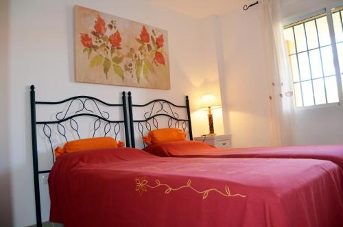 a bedroom with a bed with a red blanket at Albatros Playa 3 - 6008 in Mar de Cristal