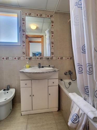 a bathroom with a sink and a mirror and a tub at Ribera Beach 3 - 0809 in Mar de Cristal