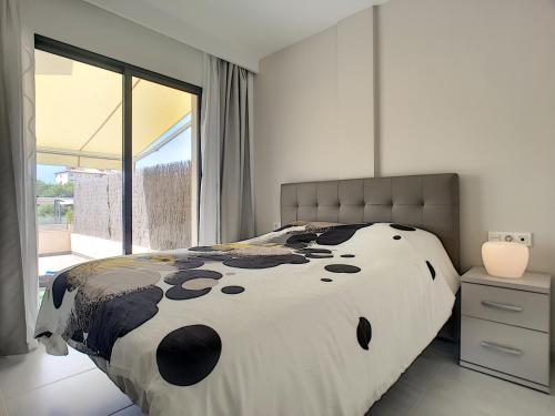 プレヤス・デ・オリフエラにあるSabrina Apartment - La Zenia - 1610のベッドルーム1室(大きなベッド1台、大きな窓付)