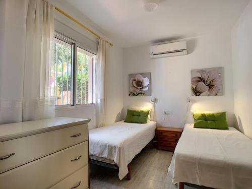 two beds in a bedroom with a dresser and a window at Villa Perla - Puerto de Mazarron in Puerto de Mazarrón