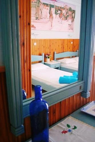 a blue bottle is sitting in front of a mirror at Diamanto Rooms in Eretria