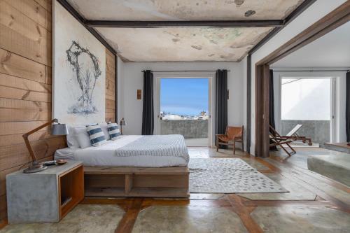 1 dormitorio con cama, mesa y ventanas en Ipanema Hills Loft, en Río de Janeiro