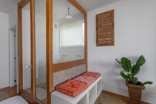 baño con banco y espejo en Ipanema Hills Loft, en Río de Janeiro