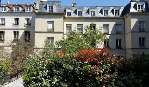 a large white building with trees in front of it at Assia & Nathalie - Luxury B&B MARAIS in Paris